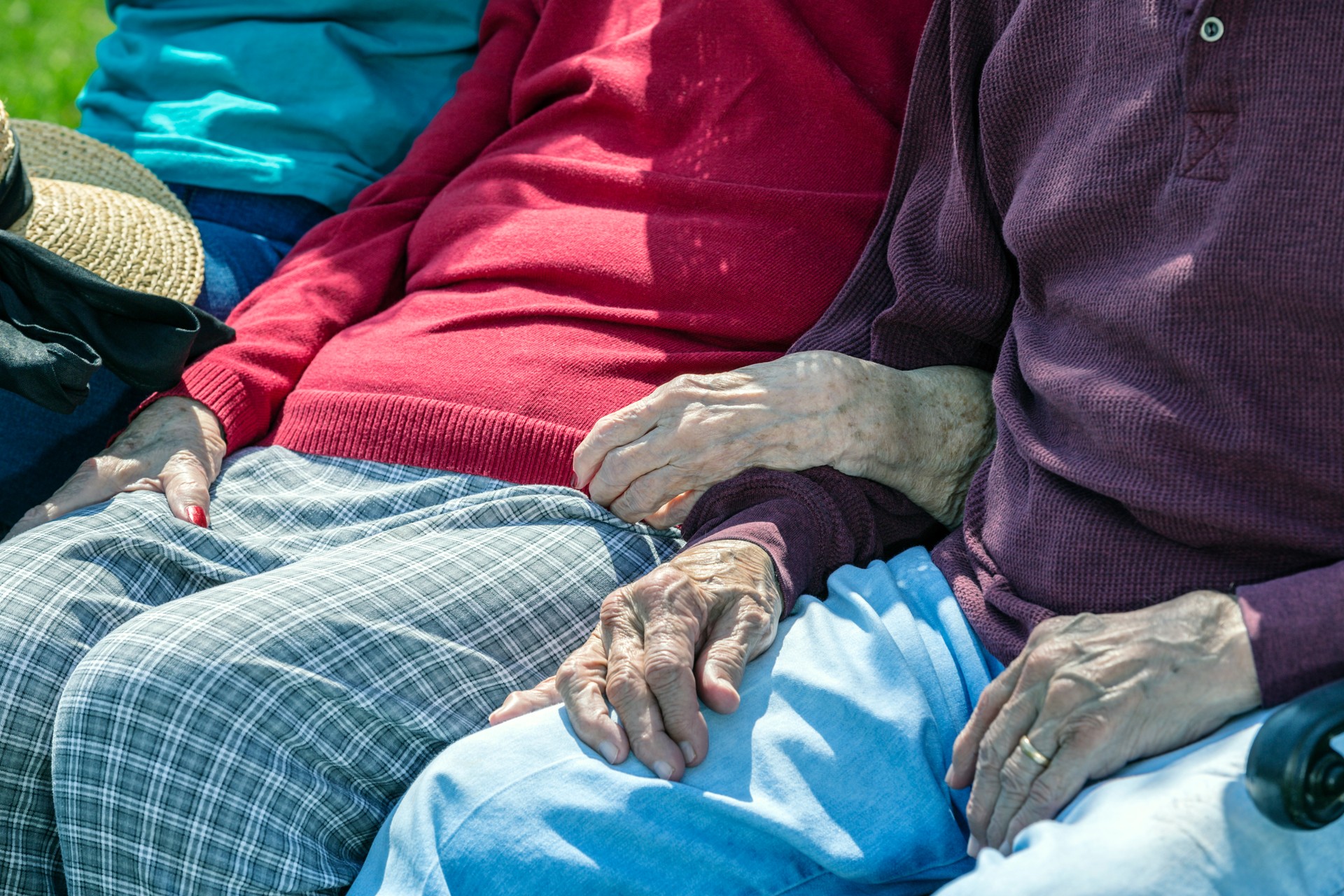 Elderly Parents Arm in Arm Sitting With Home Caregiver Daughter